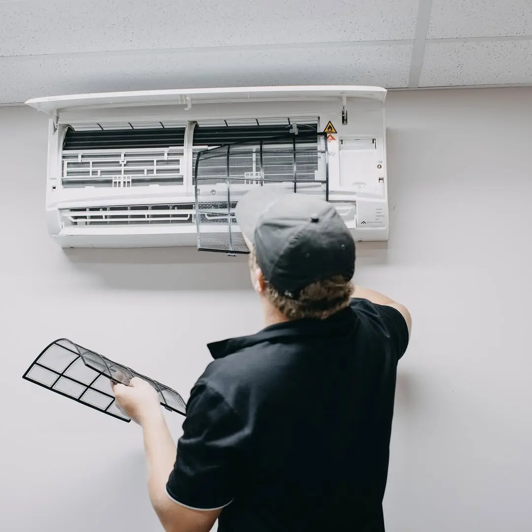 Commercial HVAC technician servicing a rooftop condensing unit